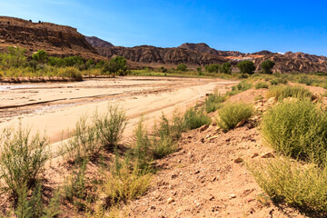 A dry, rocky desert landscape with a river running through it