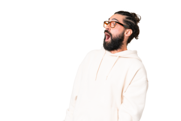 Young man with beard over isolated chroma key background doing surprise gesture while looking to the side