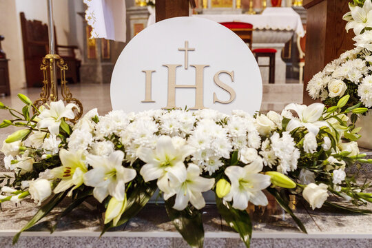 Flower decorations for the first Holy Communion with the inscription IHS, holy sacraments, Christianity
