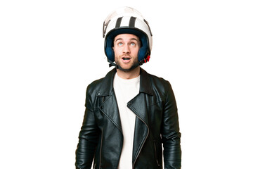 Young handsome blonde man with a motorcycle helmet over isolated chroma key background looking up and with surprised expression