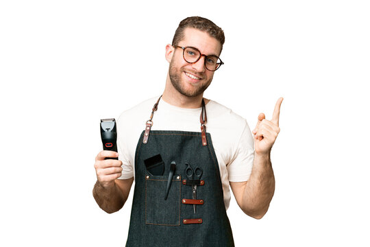 Barber man in an apron over isolated chroma key background showing and lifting a finger in sign of the best
