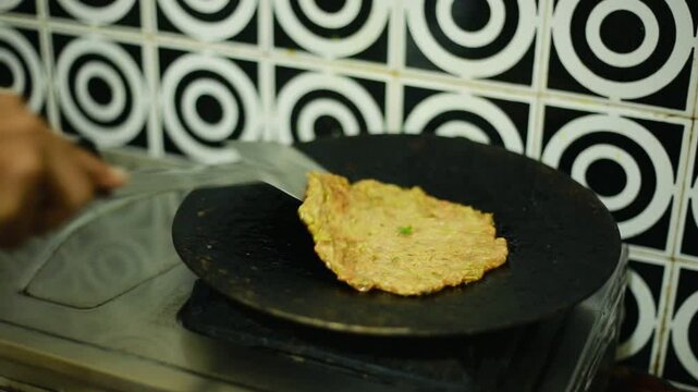 An Indian woman cooking on the stove