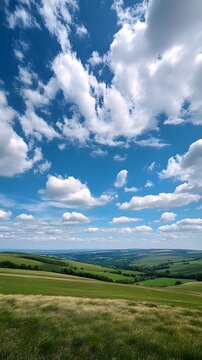 31. A sweeping view of rolling hills under a bright blue sky dotted with fluffy clouds