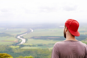 Back, fresh air and man in nature, travel and tourism of environment in woods, view and countryside. Outdoor, scenery and holiday for person in forest, sustainability and location for vacation