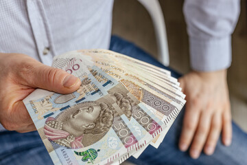 Poland Money. Confident Businessman holding out his hand with Polish banknotes. Lots of cash, 200 and 500 zloty. Financial business concept