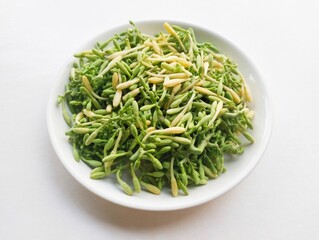 High angle view of uncooked papaya flower vegetables in a white plate on a white background. 
