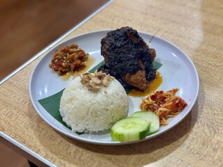 The bold flavors of Ayam Bumbu Madura, perfectly paired with steamed rice and a tangy Sambal Mangga – a delicious Indonesian feast. Serpong, Indonesia - February 2, 2025, food, meat, steak, beef, meal