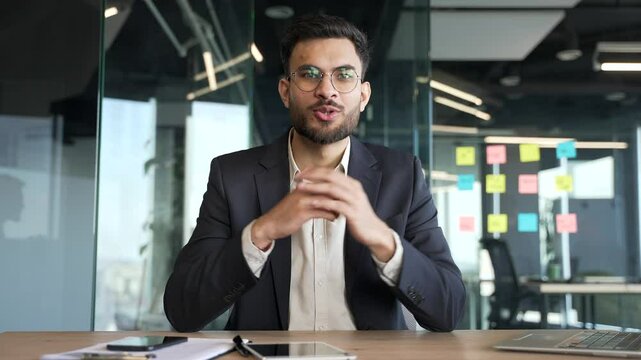 Webcam view. Confident businessman in a formal suit talking on a video call looking at camera sitting in office. Entrepreneur has a business meeting. Manager speaks remotely at an online conference