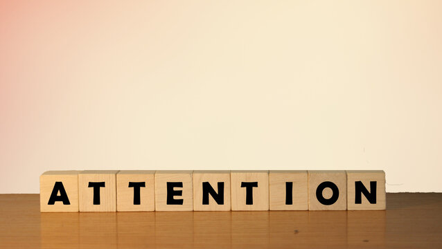 This photo features wooden blocks spelling the word "Attention," creating a compelling visual message. Ideal for marketing, education, or communication themes.