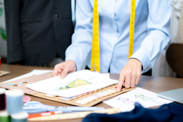 A female designer is creating clothing designs in her studio.