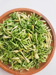 Close-up of papaya flower vegetables in a wooden plate on a white background. 