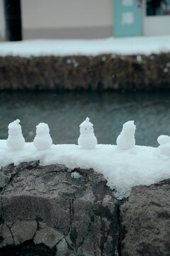 Cute small snow dolls at the riverbank of Otaru Canal. Perfect as travel wallpaper or background