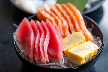 Sashimi set, Salmon, Tuna and Tamago with vegetable and ice in a bowl, served in a restaurant