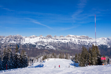 Fototapeta premium Scenic snowy landscape with Churfirsten mountain peaks in the background at Swiss ski resort Flumserberg on a winter day. Photo taken January 29th, 2025, Flumserberg, Switzerland.