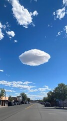 Fototapeta premium Isolated Lenticular Cloud Over a Quiet Street Under Bright Blue Sky