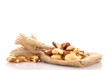 Brazil nuts without shells with jute bag, macro, isolated on white background.