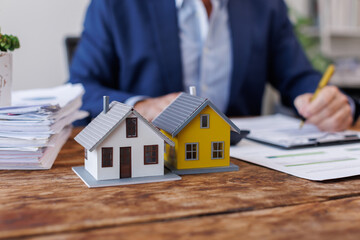Real estate broker agent presenting and consult to customer to decision making sign insurance form agreement, buy and sell home model, concerning mortgage loan offer for and house insurance