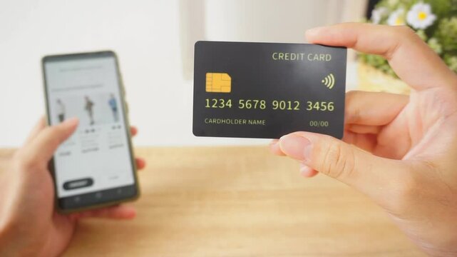 Pov first person holding black mockup credit card for online shop on smartphone at home	