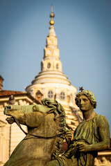 Fototapeta premium Turin, Italy. The entrance to the Royal square in front of the Royal Palace is watched by two bronze statues of the Dioscuri. Here with the Guarini's Dome of San Lorenzo in the background.