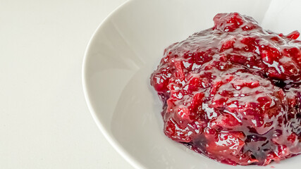 Bowl of fresh cranberry sauce, ideal for Thanksgiving celebrations and adding a tangy touch to...