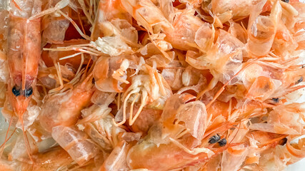A close-up of fresh, pink shrimp shells captures seafood cuisine's essence, perfect for summer grill recipes or Cajun celebrations