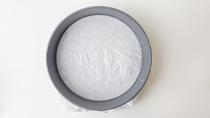 A round cake pan filled with white sugar sits on a table, symbolizing baking preparation and sweet dessert concepts