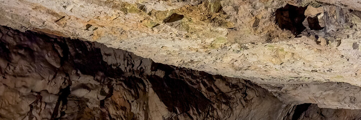 A rugged limestone cave ceiling showcasing natural geological formations, ideal for concepts of exploration, nature, and adventure tourism