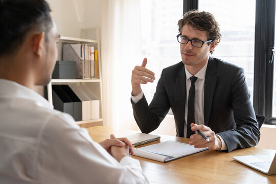 interviewer on the table asking question applicant in the office.