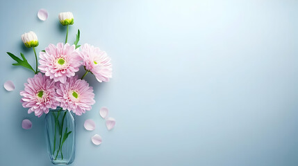 Fototapeta premium Pink chrysanthemum flowers in glass vase on blue background, floral arrangement, pastel colors, copy space, ideal for greeting card