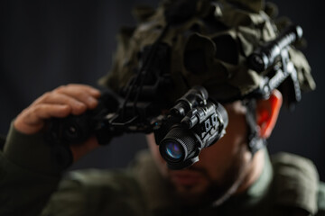 Modern night vision binocular mounted on a military tactical helmet, close-up photo.