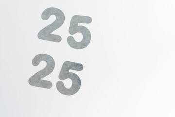 galvanized sheet metal die-cut numbers 25 x 2 on blank paper
