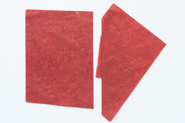 Fototapeta premium two sheets of textured red paper on white