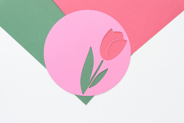stencil with tulip flower shape machine-cut from pink paper and arranged on green, red, and blank...