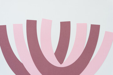 machine-cut pink and purple paper arcs on blank paper