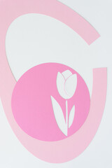 stencil with tulip flower shape machine-cut from pink paper and arranged with arc shapes on blank paper