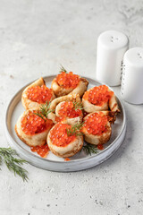 Pancake day, maslenitsa. Crepes, pancakes rolled with red caviar on white plate, gray background with text space