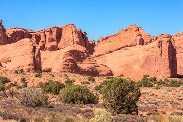 Fototapeta premium A desert landscape with a few trees and a mountain range in the background
