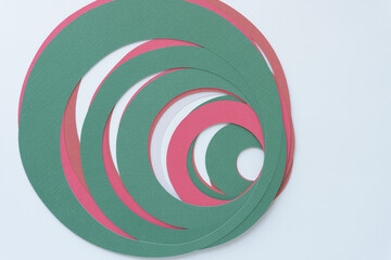mostly green and some pink concentric paper ring shapes on blank paper