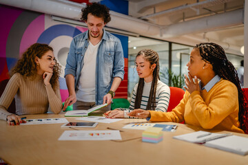male and female colleagues research together in the office