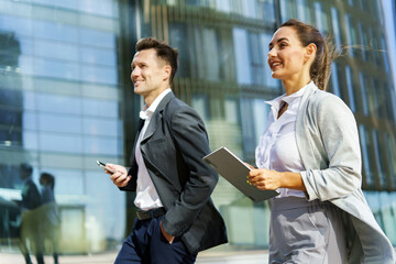 Business professionals walking together outside a modern office building during the day
