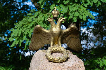 a bronze double-headed eagle with a royal crown and a laurel wreath, a symbol of the power of the Russian Empire