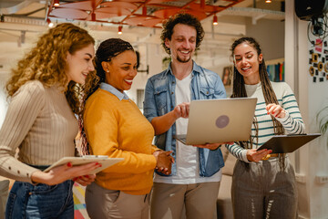 diverse group businesspeople stand and use laptop in the office