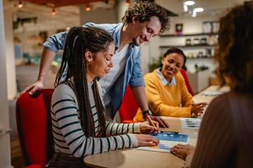 male and female colleagues research together in the office