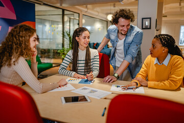 male and female colleagues research together in the office