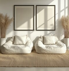 Two off white beanbag chairs sit on a beige rug against a white wall with two blank framed pictures and dried plants in vases. Natural light streams