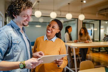 male and female multicultural colleague work together on clipboard