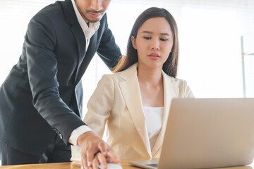 Disgusted asian young employee, pressure business woman uncomfortable, looking hand of boss or colleague  male when touching her hand while working. Sexual harassment inappropriate at office work.