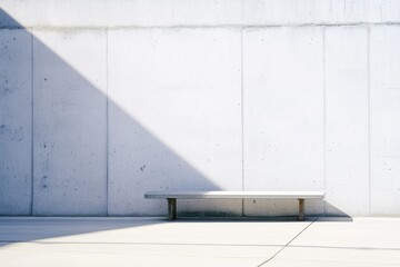 Obraz premium Embracing minimalism in skateboarding culture with a sleek concrete bench under soft afternoon light