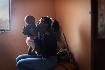 Young African mother holding baby, loving and caring expression