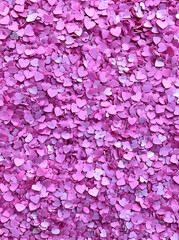 Fototapeta premium Pink background with pink heart-shaped confetti, a background filled with many small hearts, and pink paper hearts scattered on the floor, creating a romantic atmosphere with pink confetti.
